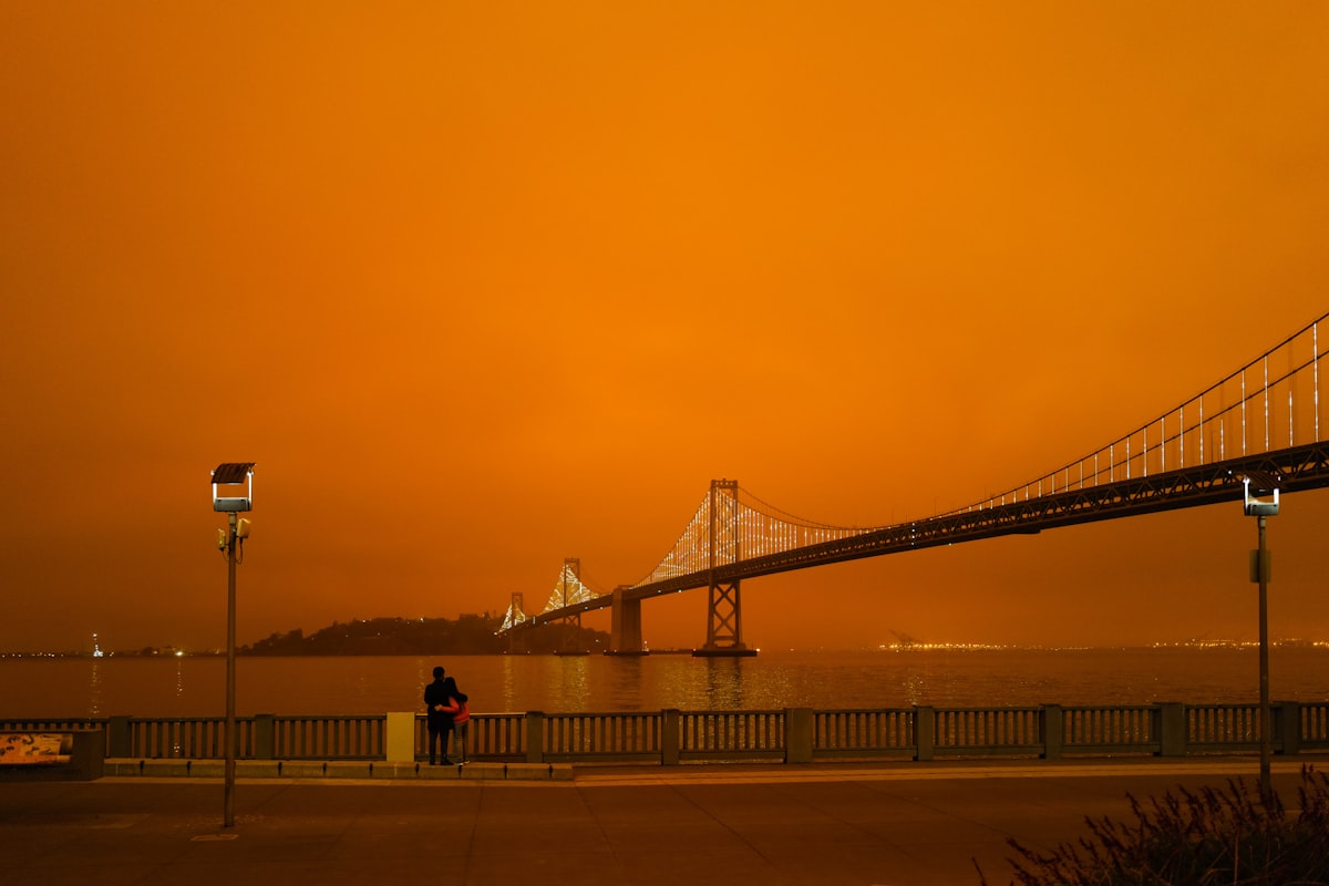 The Bay Bridge silhouetted under an orange, smoke-filled sky during a Bay Area wildfire smoke event